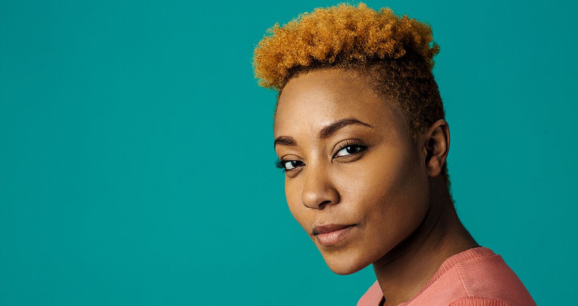 Mulher negra com o corte de cabelo curto undercut em cabelo crespo